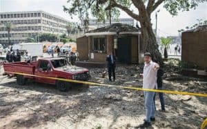 Scene in Cairo showing a damaged building, red pickup truck, and police presence, highlighting the city's complex environment and attractions.