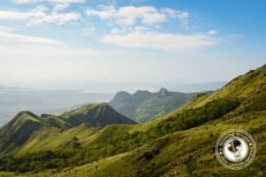 Scenic view of rolling green hills and distant mountains in Altos de Campana National Park, showcasing natural beauty and landscape diversity.