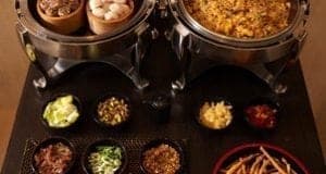 Breakfast spread featuring dim sum and fried rice with assorted toppings and sauces, showcasing culinary diversity for travel and food enthusiasts.