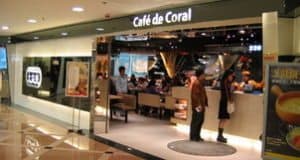Café de Coral restaurant entrance showcasing modern decor, diners inside, and signage, highlighting a popular dining experience for travelers and food enthusiasts.