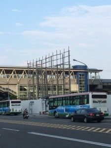 Airport exterior with buses and vehicles in foreground, showcasing transportation options for travelers.