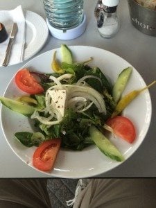 A plate of food on a table - Greek salad