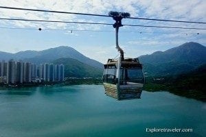 Cable car gliding over tranquil water with mountains in the background, representing travel experiences and fjord exploration on ExploreTraveler.