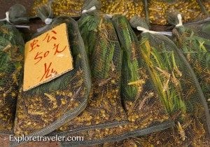 Bags of dried herbs and spices with price tags displayed at a market, representing travel commodities and local flavors.
