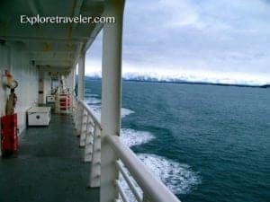 Ferry deck view in Ketchikan, Alaska, showcasing ocean waves and distant mountains, part of ExploreTraveler's travel content.