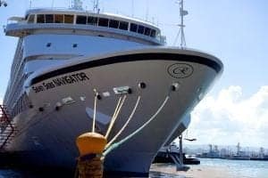 Cruise ship named "Sea Navigator" docked at port with visible mooring lines and clear blue sky, representing travel and exploration themes.
