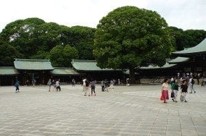 Meiji Shrine courtyard in Shibuya, Tokyo, featuring visitors, traditional architecture, and lush greenery.