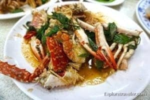 Chilli Crab dish featuring crabs in a spicy sauce, garnished with herbs, highlighting a popular seafood delicacy for culinary tourism.