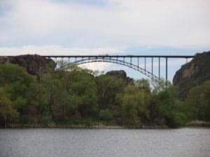 Arch Bridge spanning a river with lush greenery surrounding, showcasing a scenic travel destination.