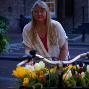 A woman standing in front of a flower - Anne Frank House