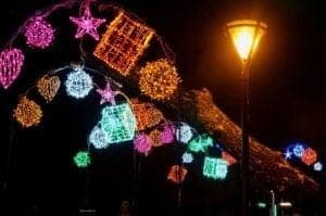 A close up of a traffic light is lit up at night - Christmas lights