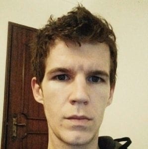 Person with short, tousled hair and a neutral expression, emphasizing eyebrow appearance in travel-related context.