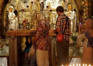 Christians Experience Holy Week In Jerusalem - A person standing in front of a store - Church of the Holy Sepulchre