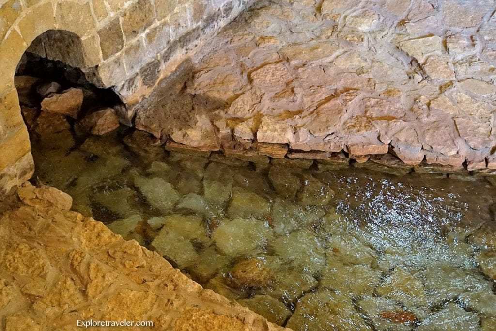 Mata air penyembuhan ‎Elisha's Fountain di Yerikho - Tampilan dekat dari batu - Air