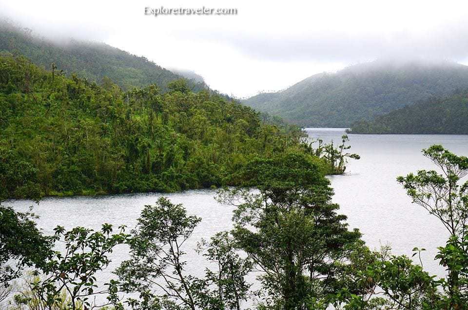 Pambansang Parke Lawa ng Danao, Pilipinas - Ein von Bäumen umgebenes Gewässer mit dem Göygöl-See im Hintergrund - Danao-See