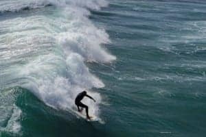 Fun In The Sun At Oceanside California USA - A man riding a wave on a surfboard in the ocean - Surfing