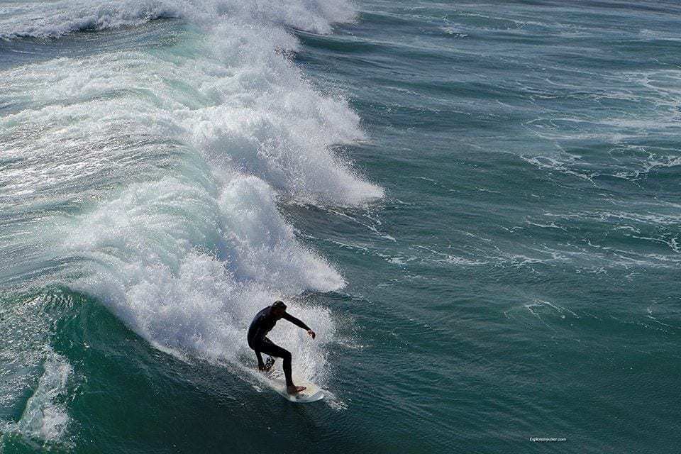 Spaß in der Sonne bei Oceanside California USA - EIN Mann, der auf einem Surfbrett im Ozean eine Welle reitet - Surfen