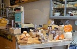 Bakery display with various breads, cheeses, and jars of preserves, showcasing local culinary offerings in a travel context.
