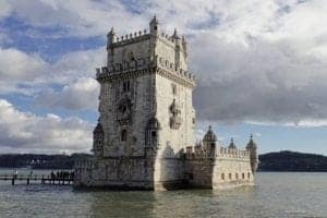 ExploreTraveler Presents: Exploring Lisbon Portugal Part 1 - A castle on a cloudy day with Belém Tower in the background - Belém Tower
