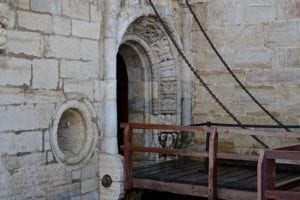Belem Tower entrance with stone archway and wooden bridge, highlighting historical architecture in Lisbon, Portugal.