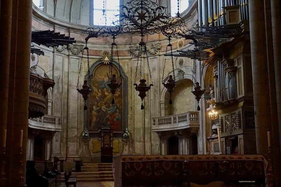 Exploring Sé de Lisboa Cathedral In Lisbon Portugal - A room filled with furniture and a fireplace - Lisbon Cathedral