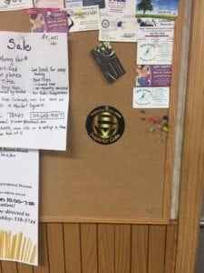 Bulletin board displaying various travel-related flyers, notices, and a logo, serving as a resource hub for travelers seeking tips and information.
