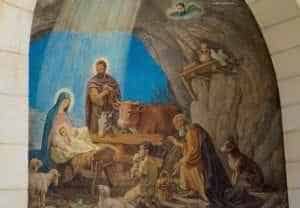 The Church Of The Nativity In Bethlehem Israel - A group of people sitting on the side of a building - Christmas Day