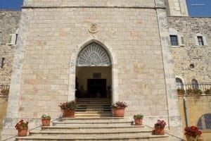 The Church of Saint John the Baptist ~ Birth Place Of John The Baptist - A stone church with a clock on the front of a brick building - Church of Saint John the Baptist, Ein Karem, Jerusalem