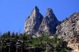 Mount Scenery in the Northern Cascades, featuring towering rock formations and lush greenery under a clear blue sky.