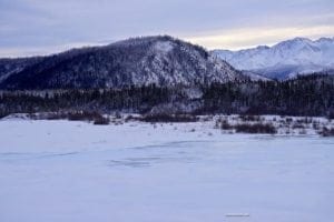 Scenic view of Mount Scenery and frozen Robertson River landscape in Eastern Alaska, showcasing winter wilderness and mountainous terrain.
