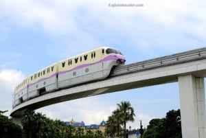 Monorail train traveling on an elevated track in Japan, showcasing innovative transportation against a blue sky and greenery, highlighting unique travel experiences.