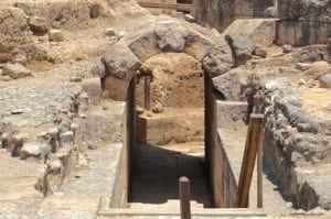Ruins of Agrippa Palace in Caesarea Philippi, featuring an arched stone entrance and surrounding archaeological site.