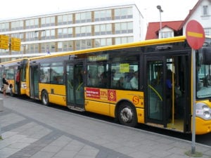 Public bus in Iceland with open doors at a stop, showcasing public transport options for travelers.