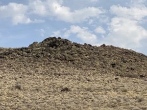 Black Rock Volcano at Petroglyph National Monument, featuring volcanic rock formations and arid landscape under a blue sky.