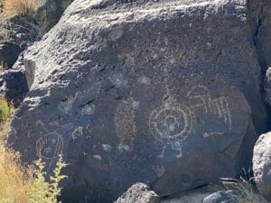 Petroglyphs on a large rock boulder at Rinconada Canyon in Albuquerque, New Mexico, showcasing ancient Native American rock art and cultural heritage.