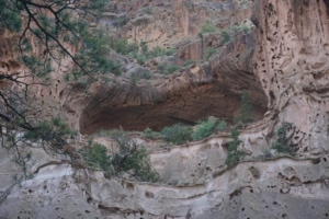 Alcove House cave at Bandelier National Monument, showcasing natural rock formations and greenery.
