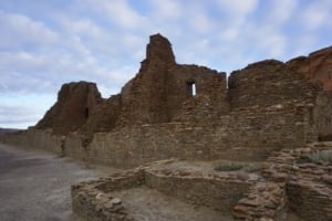 Ruins of ancient stone structures at Chaco Culture National Historical Park under a cloudy sky, showcasing the park's cultural significance and historical architecture.