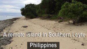 Remote island landscape in Southern Leyte, Philippines, featuring sandy beach, lush greenery, and serene ocean view.