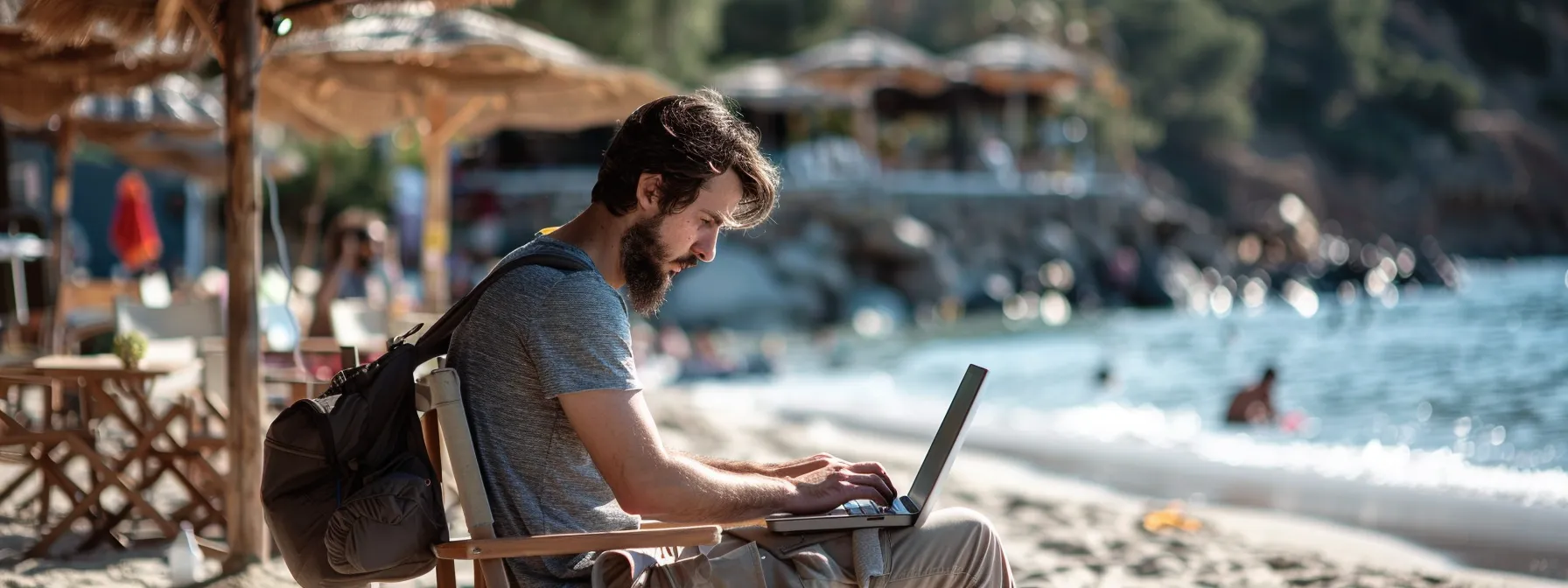 a digital nomad working on a laptop while sitting on a beach in turkey.