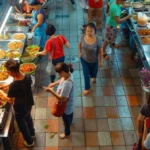 a bustling hawker stall lined with colorful, aromatic dishes and diners eagerly sampling local delicacies in penang.