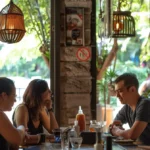 a group of digital nomads sitting together at a cafe, discussing health insurance requirements for their visa.