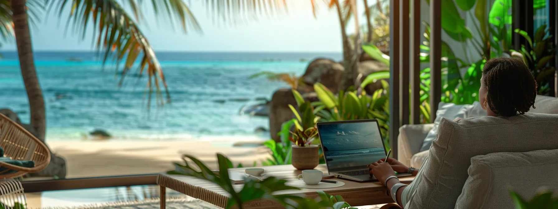 a person working on a laptop with a view of a tropical beach in the background.