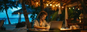 Ein digitaler Nomade prüft an einem tropischen Strand auf einem Laptop seine Visaoptionen.