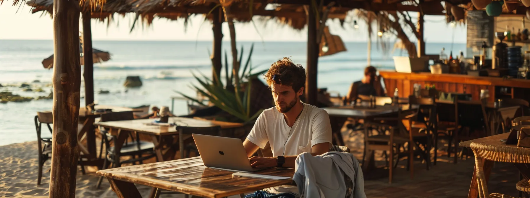 a digital nomad working on a laptop at a cozy beachside cafe in cape verde.