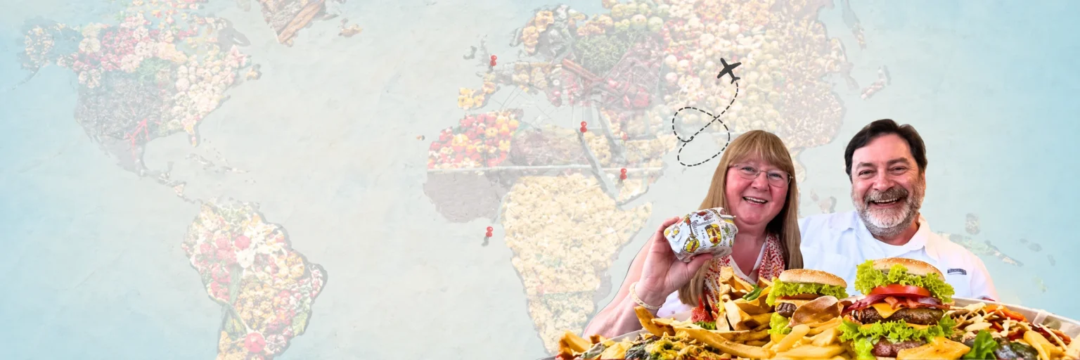John and Karen Gentry smiling together over food against a world travel map
